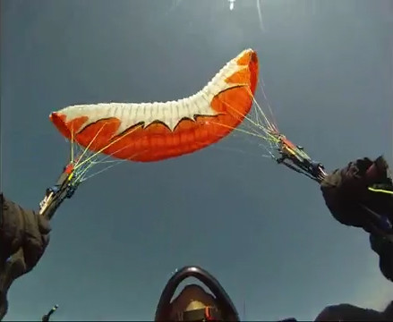 Parapente laranja fazendo vôo para trás abordo