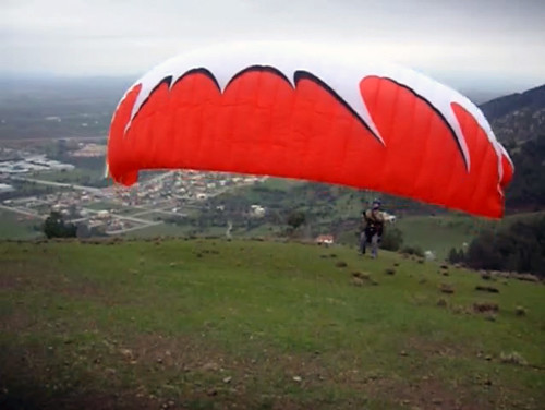 Parapente vermelho inflando para decolar