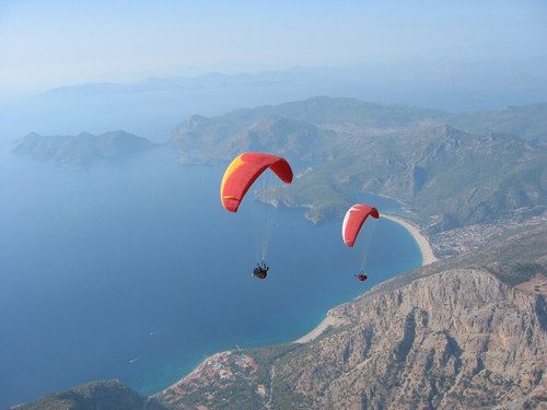 Dois parapentes vermelhos voando em Olüdeniz na Turquia
