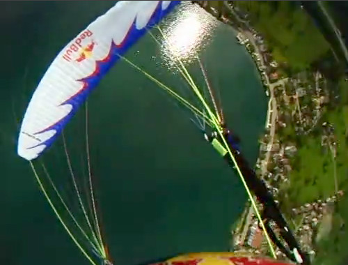 Piloto passa sobre o parapente branco abordo durante um Tumbling Assimétrico